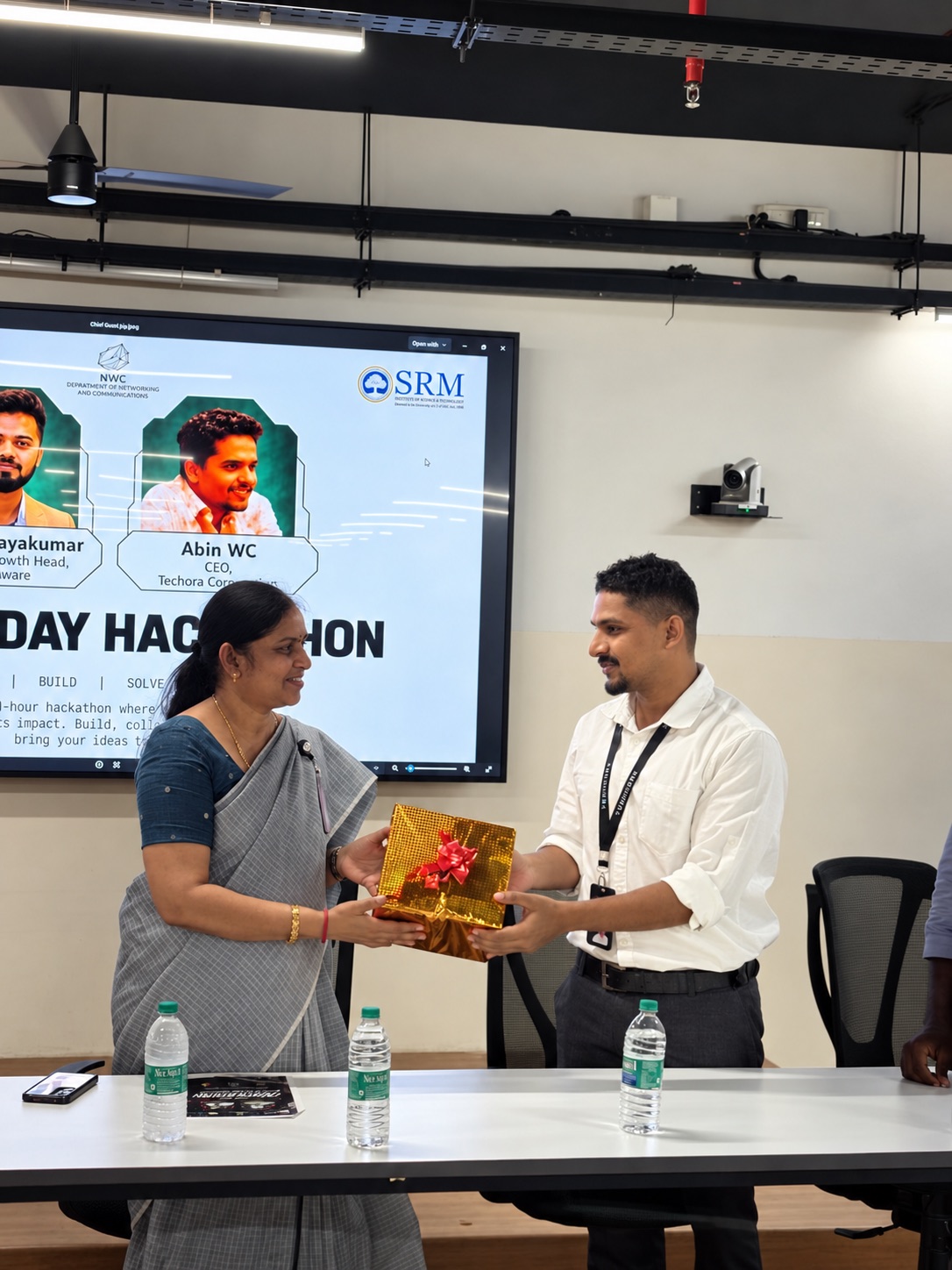 A gift being presented at the DOOMSDAY 2026 hackathon, in front of the event slide